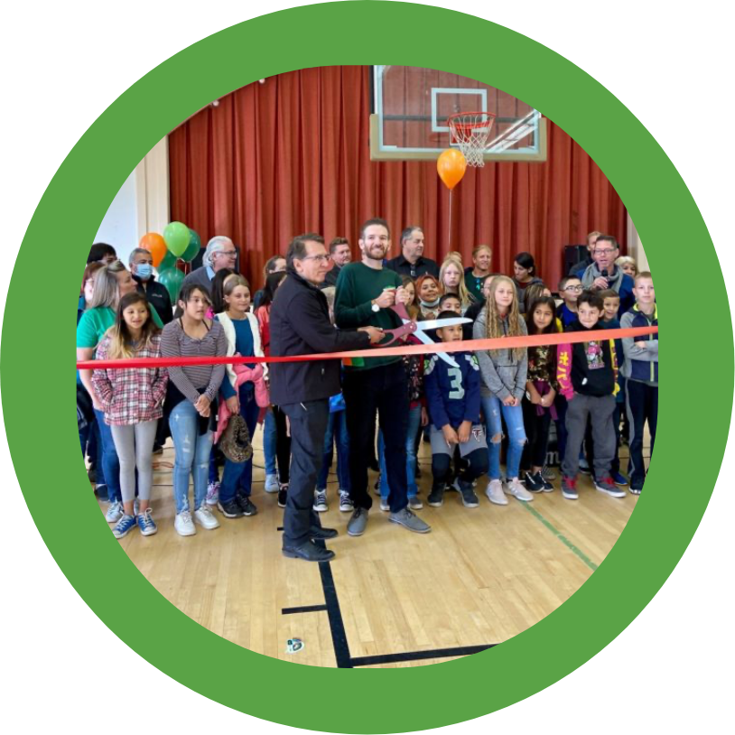 A man cutting a ribbon at an elementary school